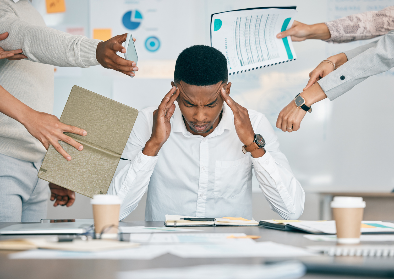 Stress, Burnout and Tired Black Man with Headache, Frustrated or Overwhelmed by Coworkers at Workplace. Overworked, Mental Health and Anxiety of Exhausted Male Worker Multitasking at Desk in Office.